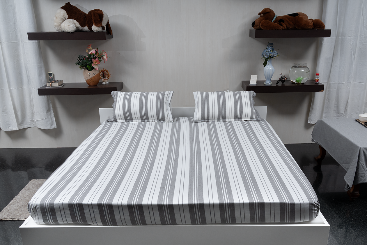 Linn Decors fitted sheet with two pillow covers and quilt styled on a modern bedroom bed