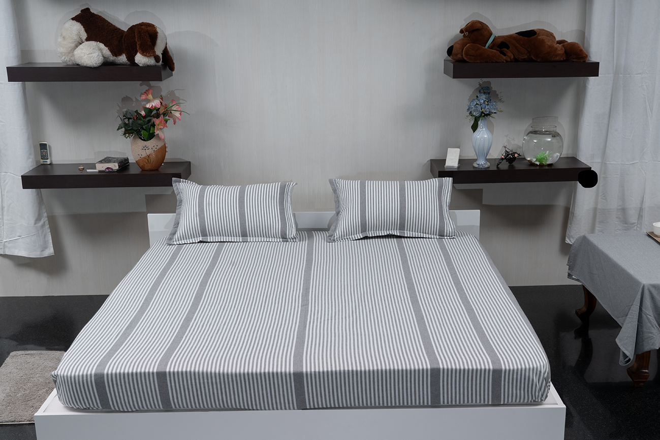 Linn Decors fitted sheet with two pillow covers and quilt styled on a modern bedroom bed