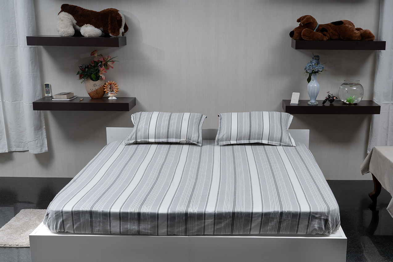 Linn Decors fitted sheet with two pillow covers and quilt styled on a modern bedroom bed