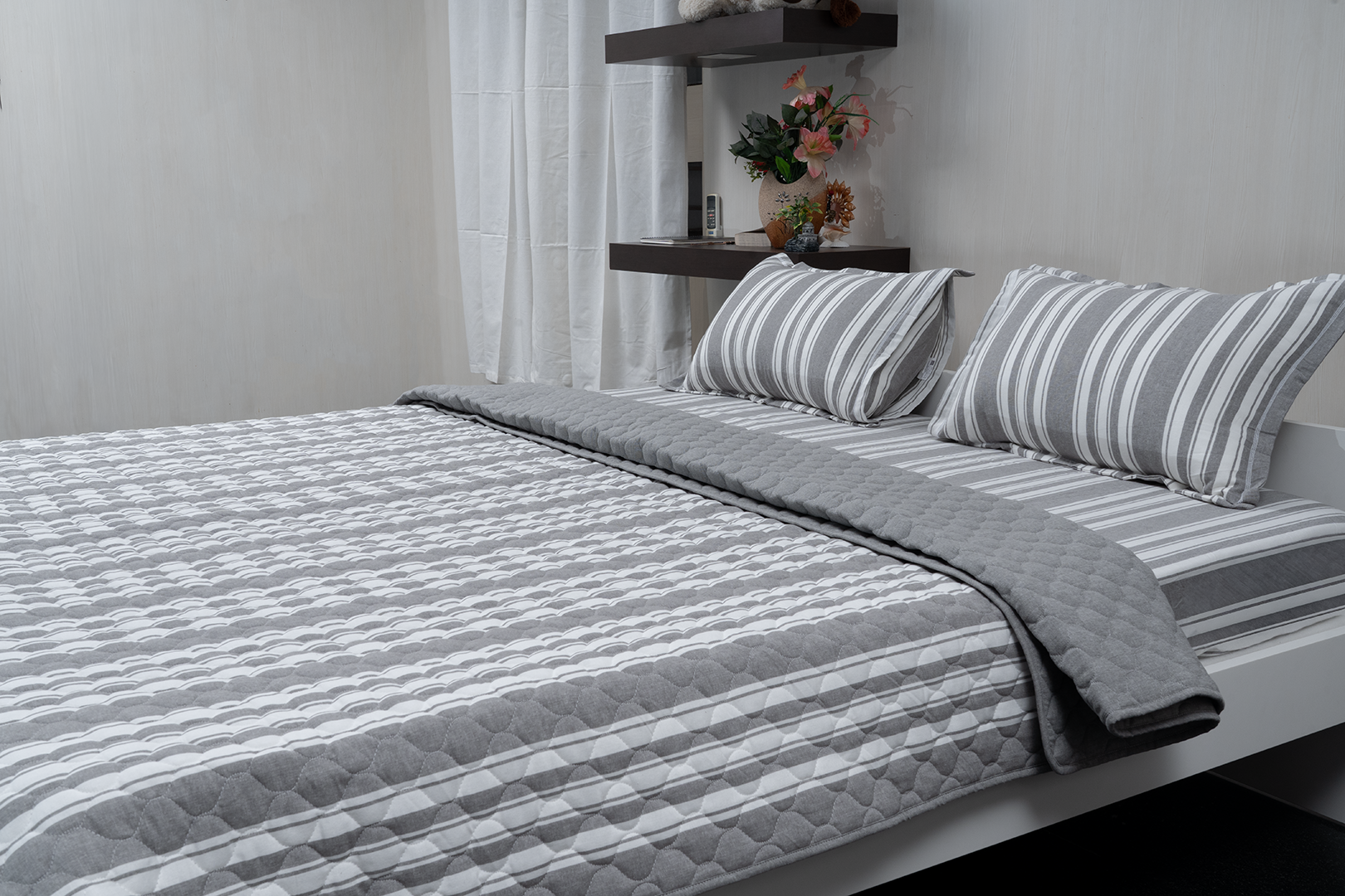 Linn Decors fitted sheet with two pillow covers and quilt styled on a modern bedroom bed